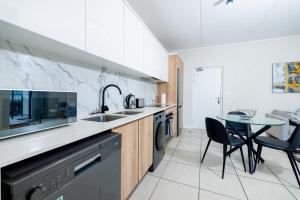 a kitchen with a sink and a table at Fynbos Lifestyle Estate - One Bed Apartment in Cape Town
