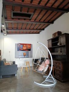 a living room with a chair and a tv at Casona Veroka in San Pedro