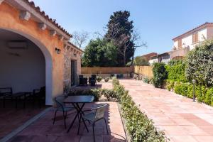 a patio with a table and chairs next to a building at Zenia Rooms in San Teodoro