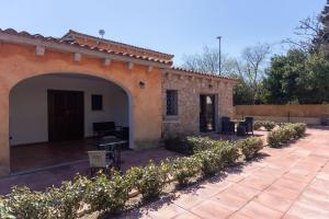 a stone house with an archway and a courtyard at Zenia Rooms in San Teodoro +30 photos