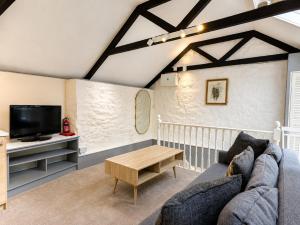 a living room with a couch and a tv at Holiday Cottage Falmouth in Penryn