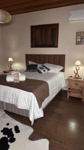 a bedroom with a large bed with white sheets at The Barn Experience - Mantiqueira in Sylvestre Ferraz