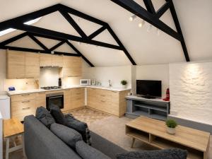 a living room with a couch and a kitchen at Holiday Cottage Falmouth in Penryn