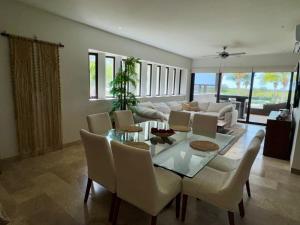ein Wohnzimmer mit Tisch, Stühlen und Sofa in der Unterkunft Telchac Ocean Suite in Xtampú