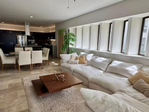 ein Wohnzimmer mit einem weißen Sofa und einem Tisch in der Unterkunft Telchac Ocean Suite in Xtampú