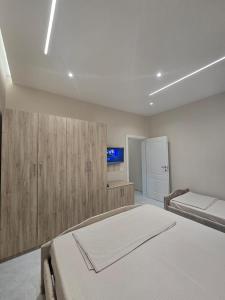 a bedroom with two beds and a tv on the wall at Kejdi Golem Central Apartment in Golem