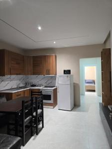 a kitchen with a table and a white refrigerator at Kejdi Golem Central Apartment in Golem