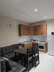 a living room with a table and a kitchen at Kejdi Golem Central Apartment in Golem +8 photos