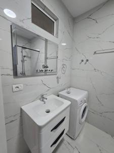 a white bathroom with a toilet and a sink at Kejdi Golem Central Apartment in Golem