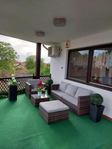 a living room with a couch and chairs on a balcony at Pagoda Vendégház in Hajdúdorog
