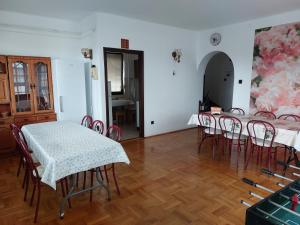 a dining room with tables and chairs and a painting on the wall at Pagoda Vendégház in Hajdúdorog