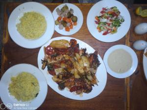 a wooden table with plates of food on it at Hamata House Camp in Abū Ghuşūn