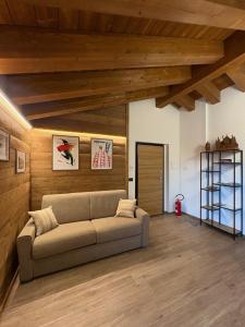 a living room with a couch and wooden ceilings at LA CASETTA - Appartamento CERVINO in Torgnon