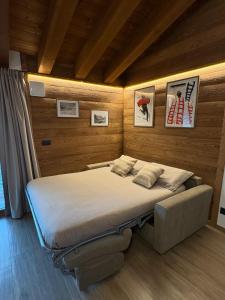 a bedroom with a large bed and a couch at LA CASETTA - Appartamento CERVINO in Torgnon