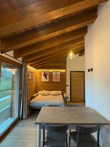a bedroom with a bed and a table and chairs at LA CASETTA - Appartamento CERVINO in Torgnon +16 photos