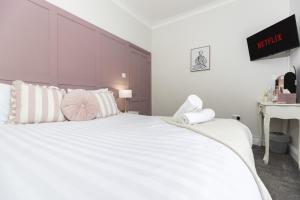 a white bedroom with a large white bed with pillows at High Lands in Cockfield