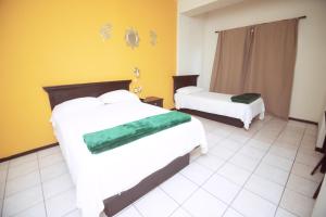 Ein Hotelzimmer mit zwei Betten und gelben Wänden in der Unterkunft Nova Departamentos in Cadereyta Jiménez