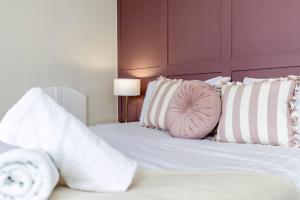 a white bed with white pillows and a pink pillow at High Lands in Cockfield +31 photos
