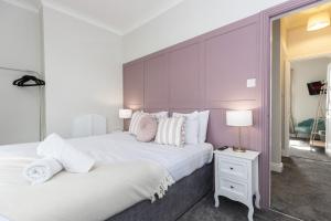 two beds in a bedroom with a purple wall at High Lands in Cockfield
