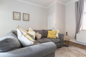 a living room with a gray couch and yellow pillows at High Lands in Cockfield
