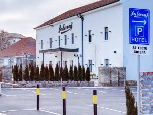 un hotel con aparcamiento frente a un edificio en Garni Hotel Zavicaj en Belgrado