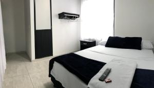 a bedroom with a bed with a remote control on it at Hotel las Palmas Lejanías - Meta in Lejanías