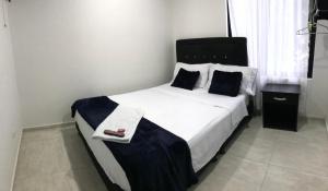 a bedroom with a large white bed with two pillows at Hotel las Palmas Lejanías - Meta in Lejanías