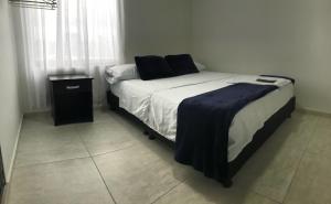 a bedroom with a bed and a night stand at Hotel las Palmas Lejanías - Meta in Lejanías
