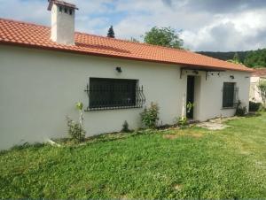 a small white house with a grass yard at Οκά & δράμι in Kaléntzion