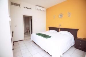 ein Schlafzimmer mit einem weißen Bett und einer gelben Wand in der Unterkunft Nova Departamentos in Cadereyta Jiménez