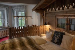 a bedroom with a bed and a wooden wall at Hotel & Restaurant Grüner Baum - Die Grüne Oase Am Feldberg in Feldberg