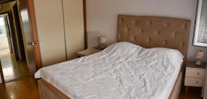 a bedroom with a bed with a white comforter at Apartmani Andjelka in Tivat