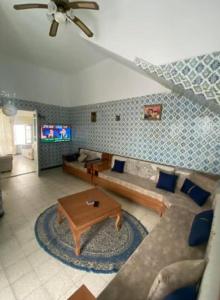a living room with a couch and a table at Dar El Mdina in Mahdia