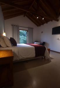 a bedroom with a large bed with a window at Doce Refugio in Santo Antônio do Pinhal