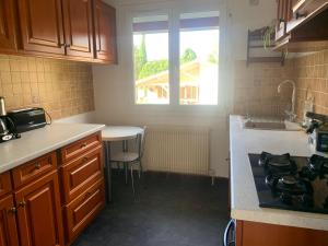 a kitchen with a stove and a sink and a window at maison moderne en face de la mer in Arès