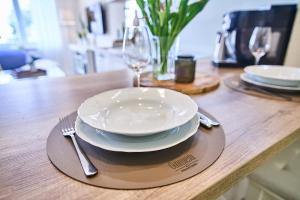 a wooden table with a plate and a fork and knife at Smart apartmány Prešov in Prešov +9 photos