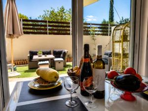 a table with two bottles of wine and wine glasses at S&M Cozy Garden Lagonissi in Lagonissi