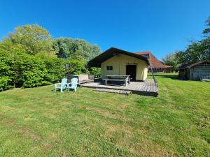 a house with a deck with two chairs and a grill at Safaritent Aesgestate in Gauw +2 photos