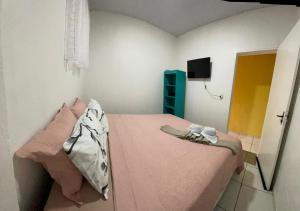 a small bedroom with a pink bed and a television at Ksa Sodré in Barreirinhas