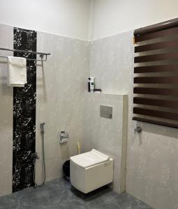 a bathroom with a white toilet and a shower at Aashiyana retreat in Duimukh