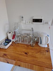 a kitchen counter with glass dishes on a wooden counter top at Hospedaje Diente de Leon in Ataliva Roca