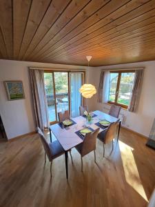 a dining room with a table and chairs and windows at Swiss Chalet direkt am Thunersee in Thun +20 photos