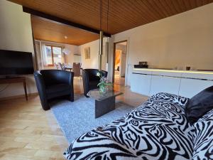 a bedroom with a zebra print bed and a living room at Swiss Chalet direkt am Thunersee in Thun