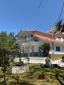 a white house with a balcony and a yard at Nadia's Beach House in Pefkari