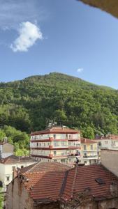 a group of buildings in front of a mountain at By The River Stay in Florina