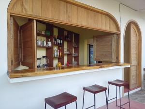 a kitchen with a bar with stools under it at Hotel Ruunda in San Agustinillo