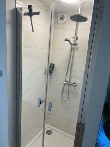 a shower with a glass door in a bathroom at Emilówka in Ostrów Wielkopolski +6 photos