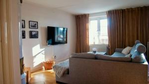 a living room with a couch and a tv at Storgatan 30 i centrala Vimmerby in Vimmerby