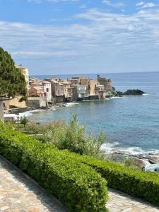 a group of buildings on the shore of the ocean at Studio tout équipé centre Erbalunga in Brando