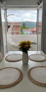 a table with plates and a vase with flowers on it at Bulatović in Ðuranovići